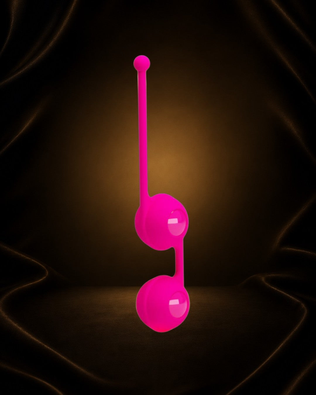 Bolas Kegel Triple Intensidad de Éxtasis Boutique en color fucsia, con dos esferas unidas por una banda flexible y un extremo con un punto.