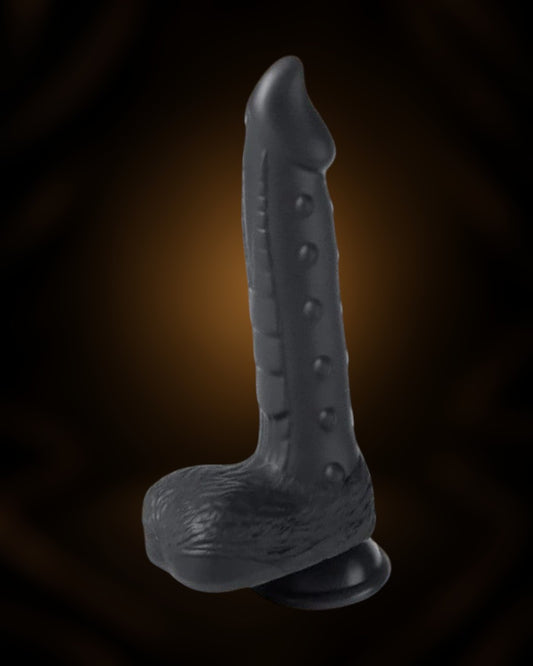 Dildo vibrador Alger negro de silicona con ventosa y textura de escamas en la base. Éxtasis Boutique.