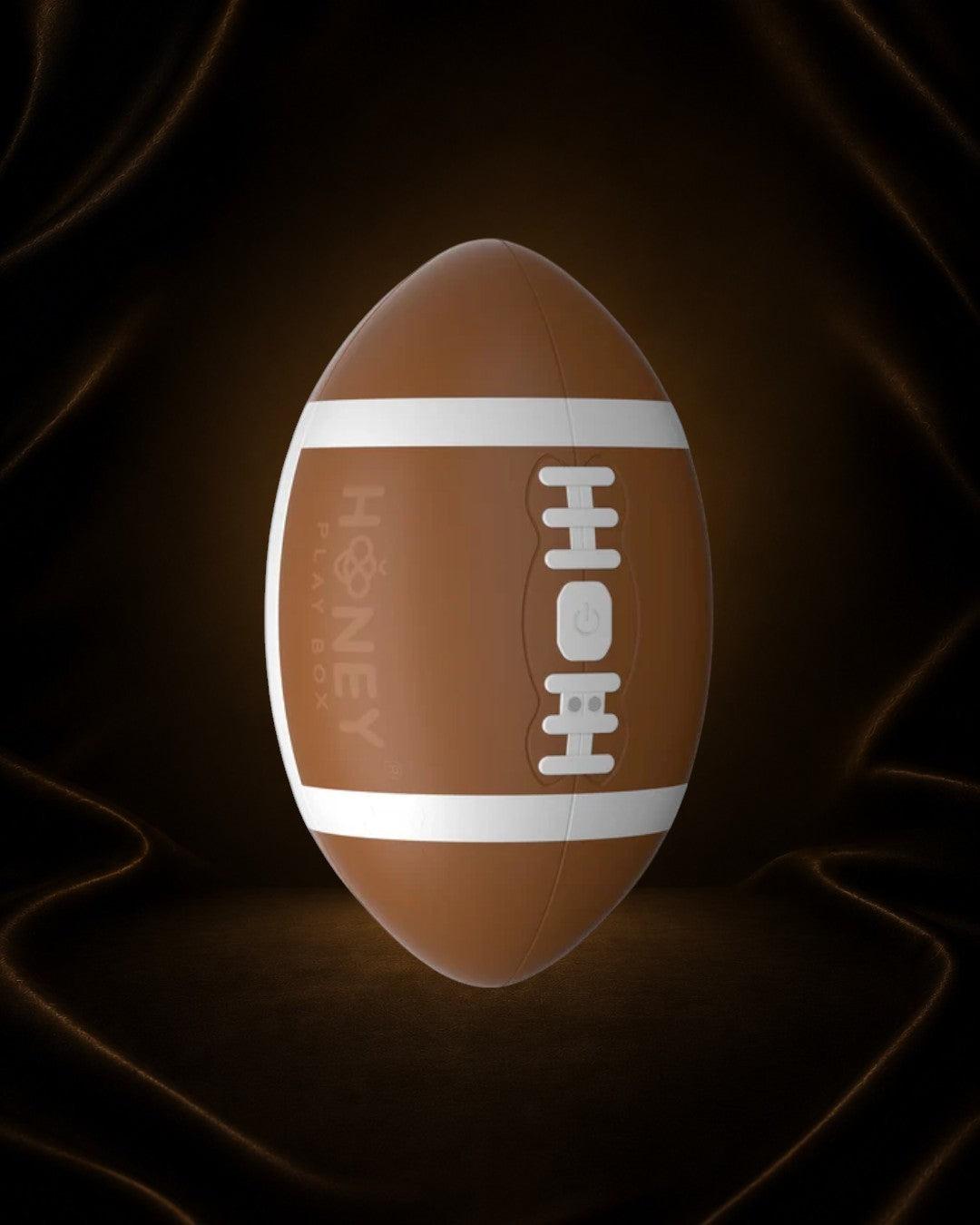 Éxtasis Boutique Masturbador Touchdown, diseño de balón de fútbol americano marrón con rayas blancas y detalles de costura, con dos motores para estimulación vibratoria.
